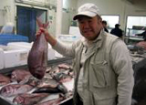 Chef Akira at the market holding a fish