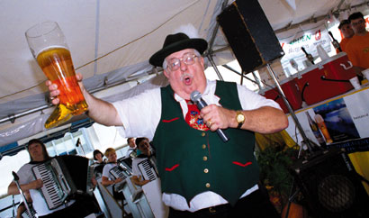 A man holds up a beer at the Oktoberfest-Zinzinnati