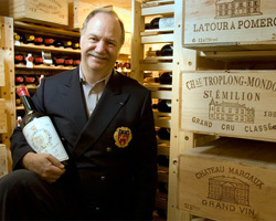 Eric Vogt, eProvenance’s founder, stands in a wine cellar with a bottle of Bordeaux