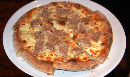 A freshly baked pizza with shaved truffles
