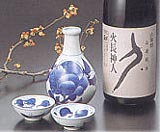 A bottle of sake with serving ware